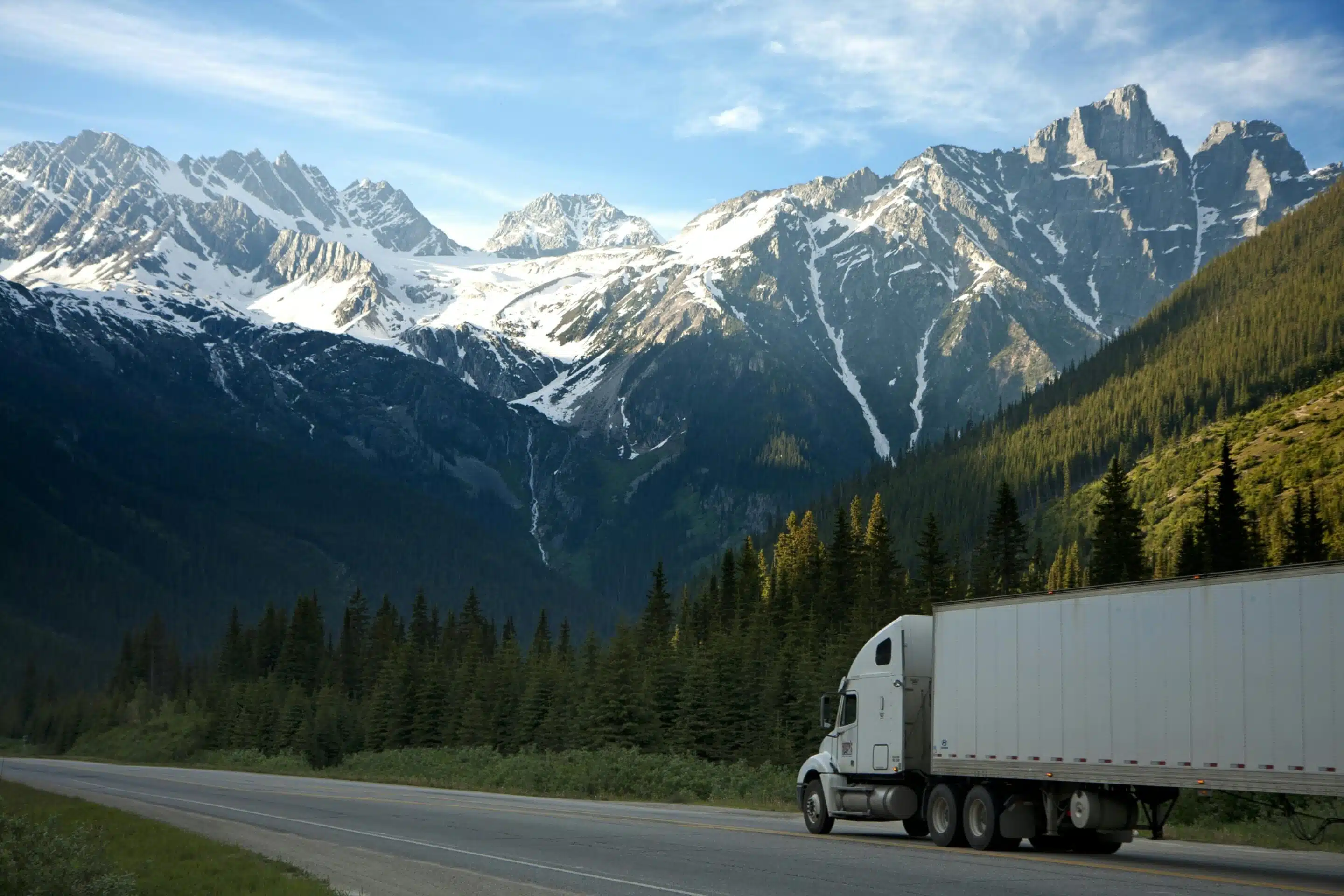 White semi truck driving in the mountains.