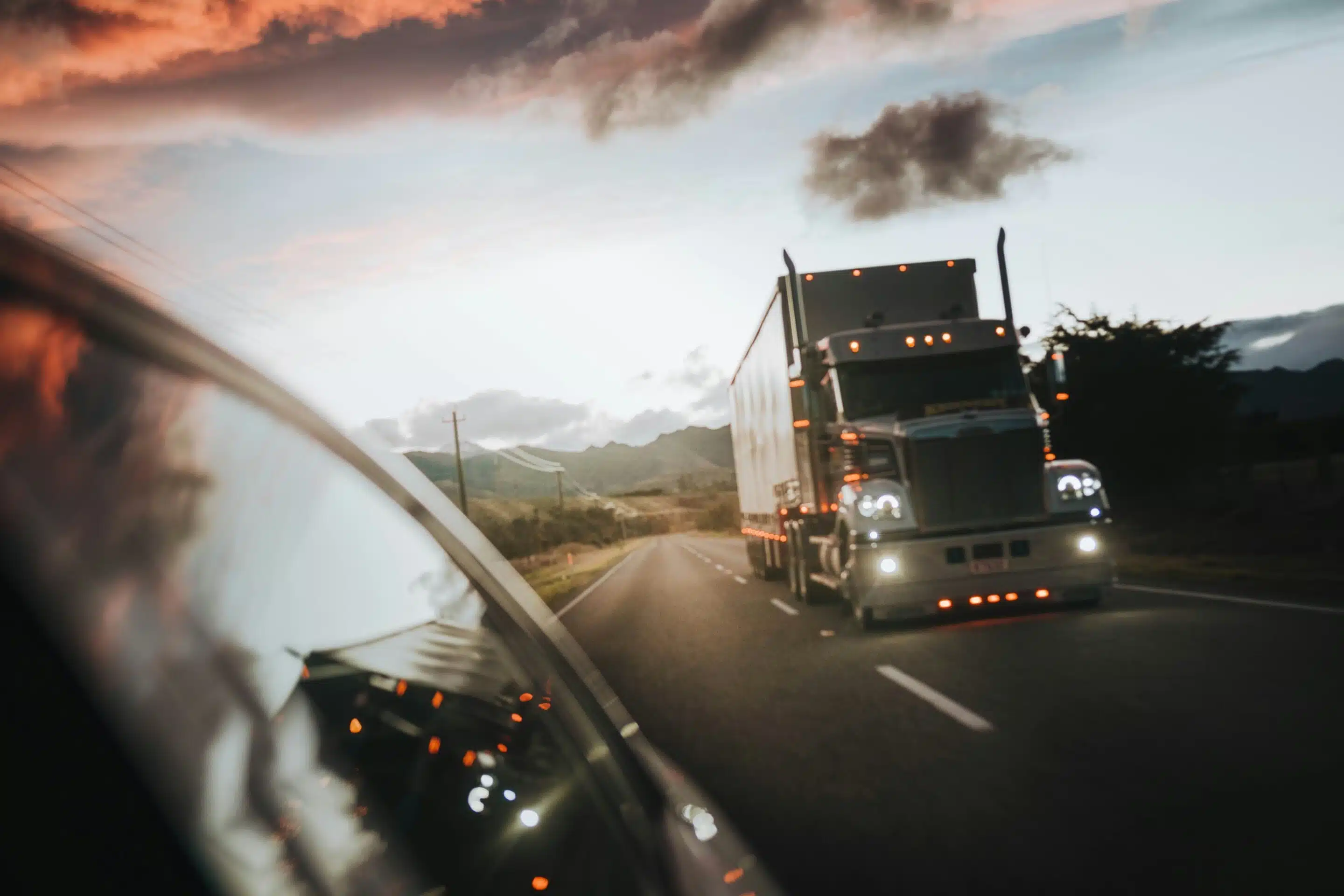 A semi truck passing a car on the interstate. 
